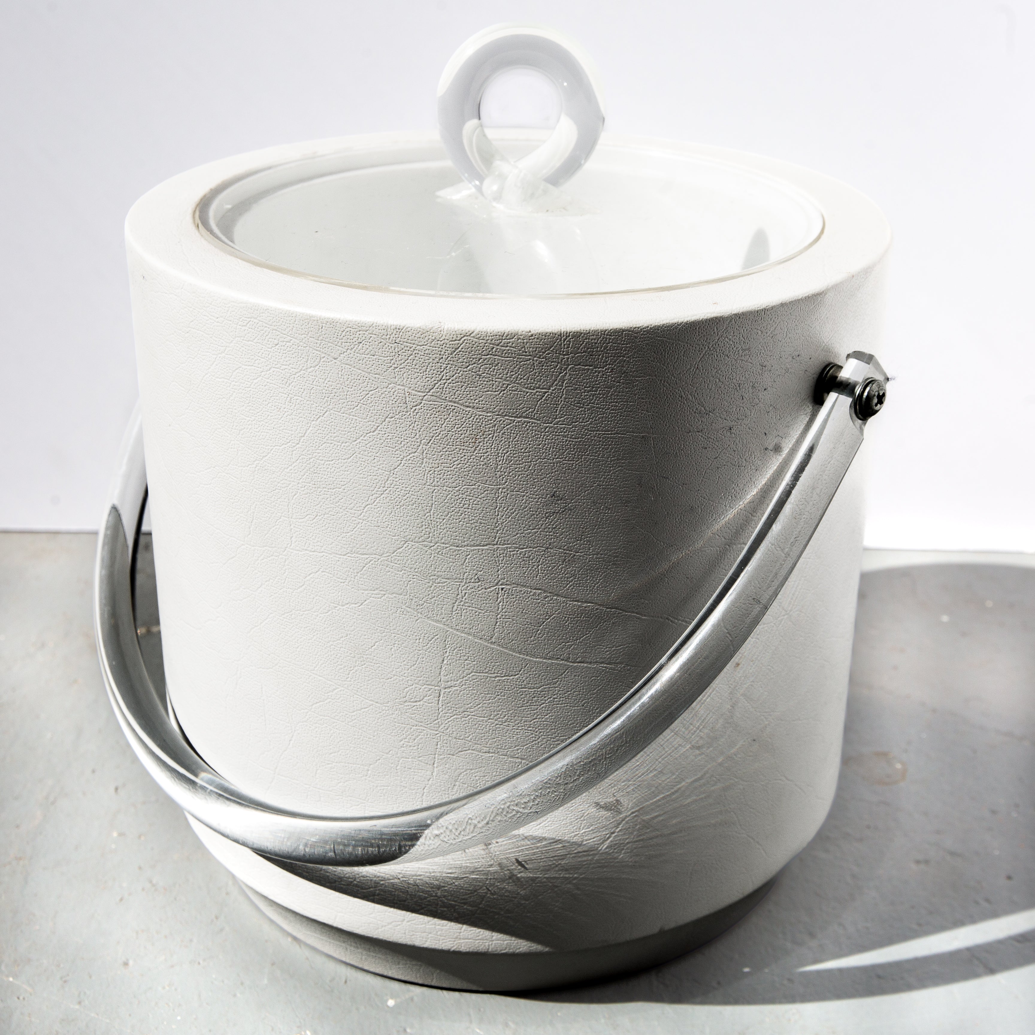 White ceramic pot with a lid on a gray surface