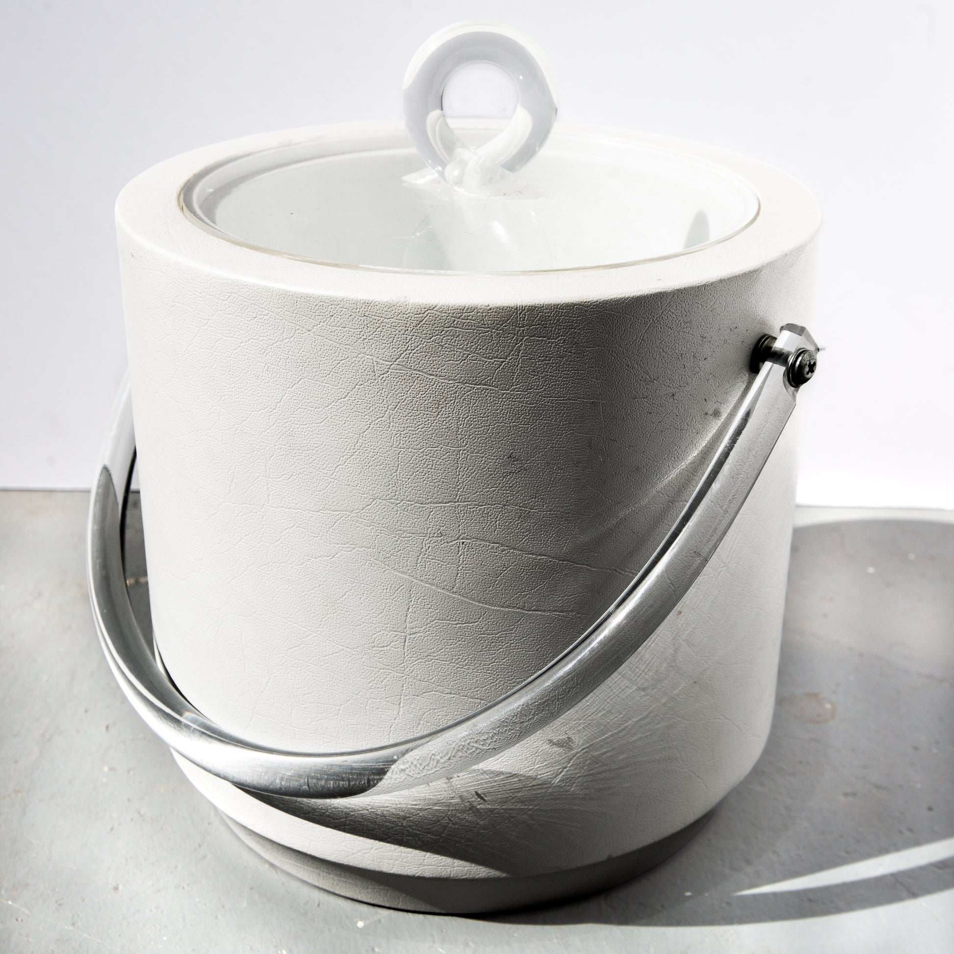 White ceramic pot with a lid on a gray surface