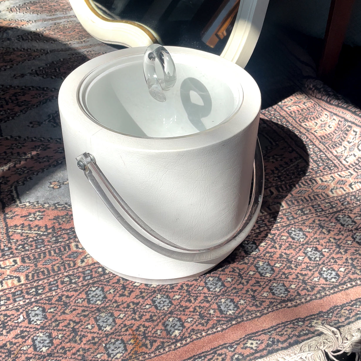 White ice bucket with lid on a patterned rug
