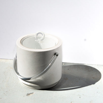 White marble ice bucket with a lid on a light gray surface