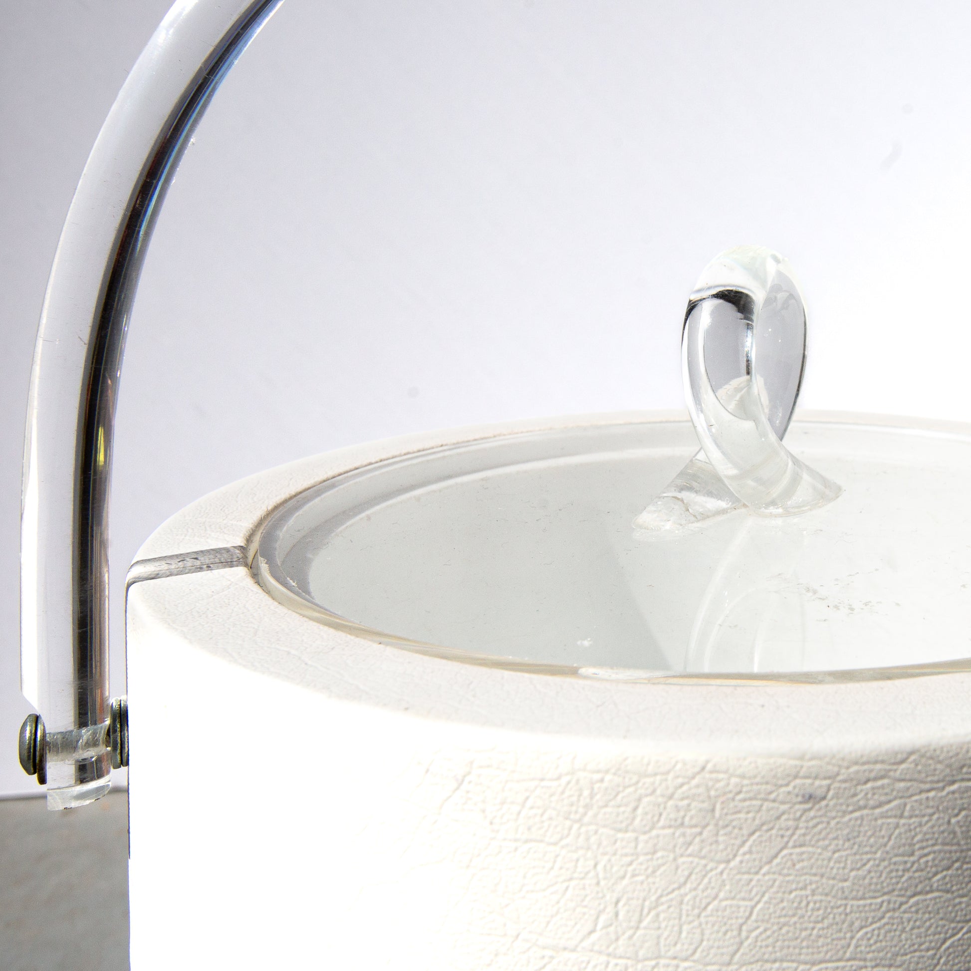 Close-up of a white ceramic bowl with a glass lid on a light gray background