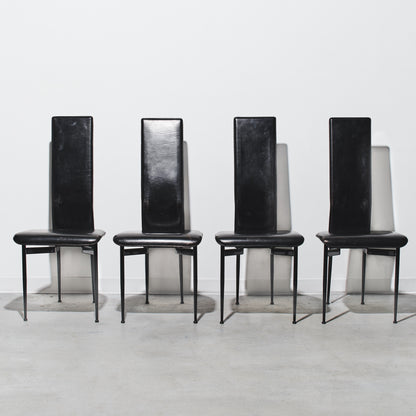 Four black chairs with high backs on a white background