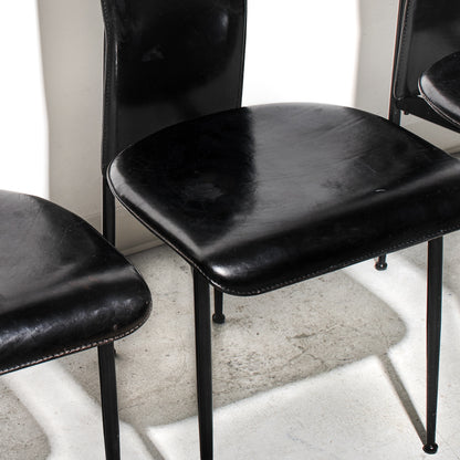 Black leather chairs with metal legs on a light-colored floor.