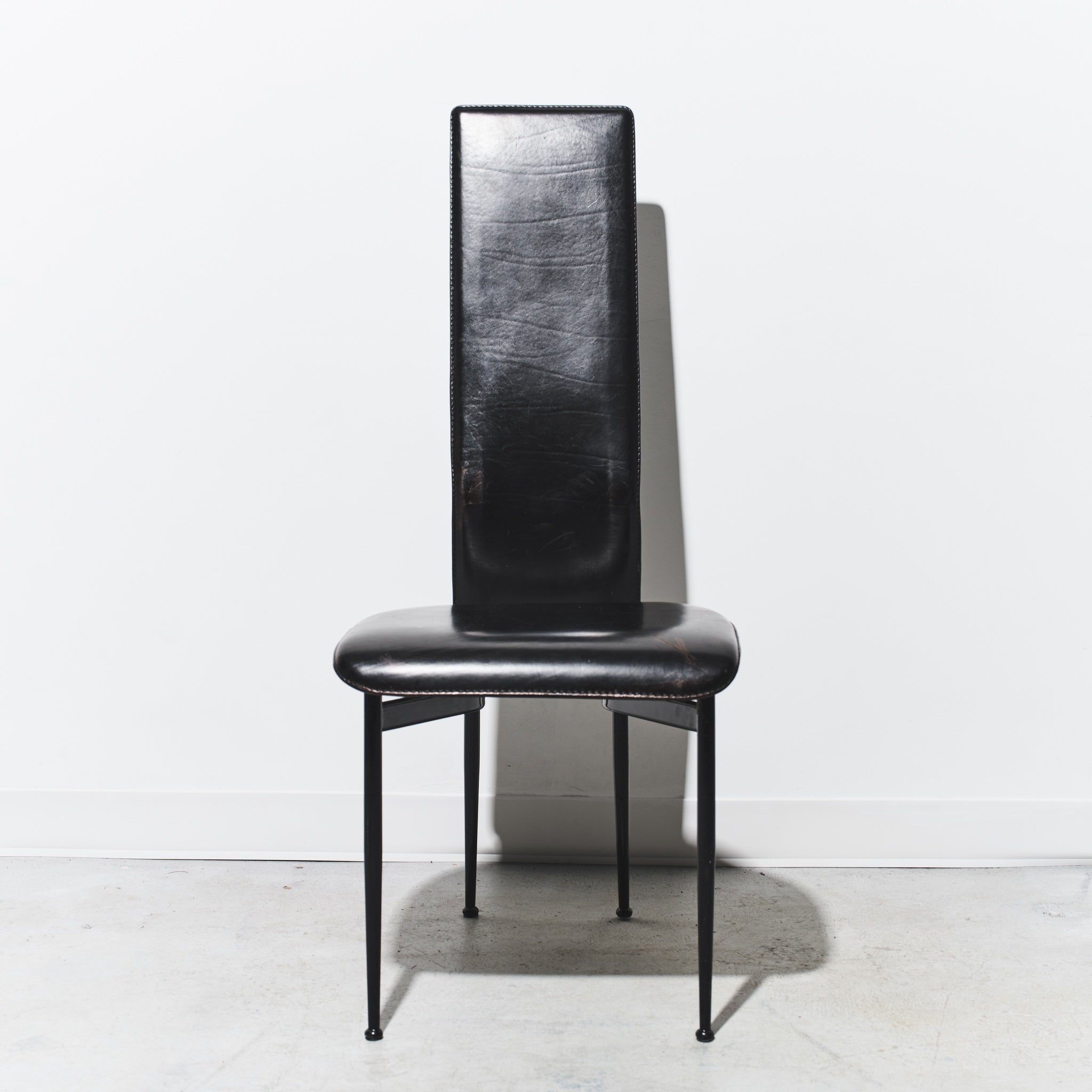 Black leather chair with a textured backrest on a white background