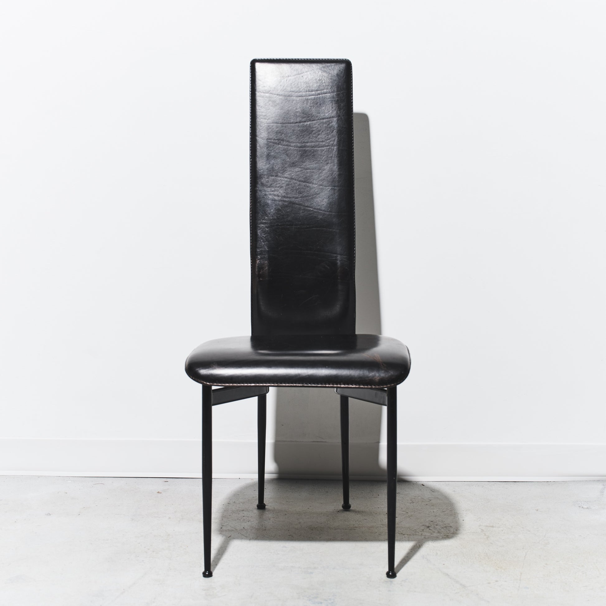 Black leather chair with a textured backrest on a white background