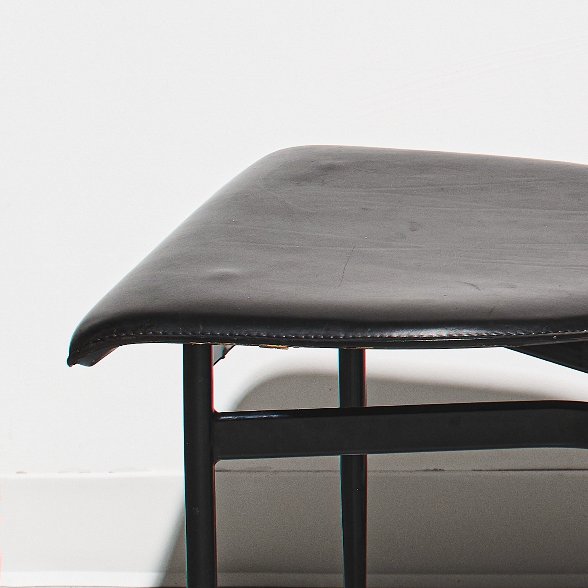 Black leather bench with metal frame on a white background
