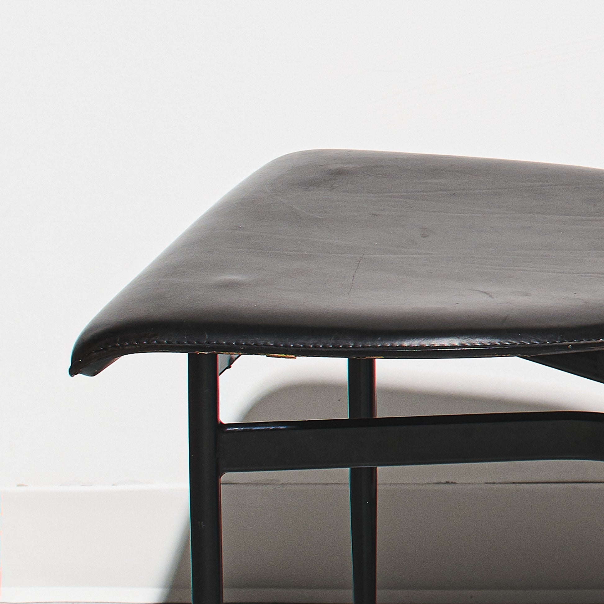 Black leather bench with metal frame on a white background