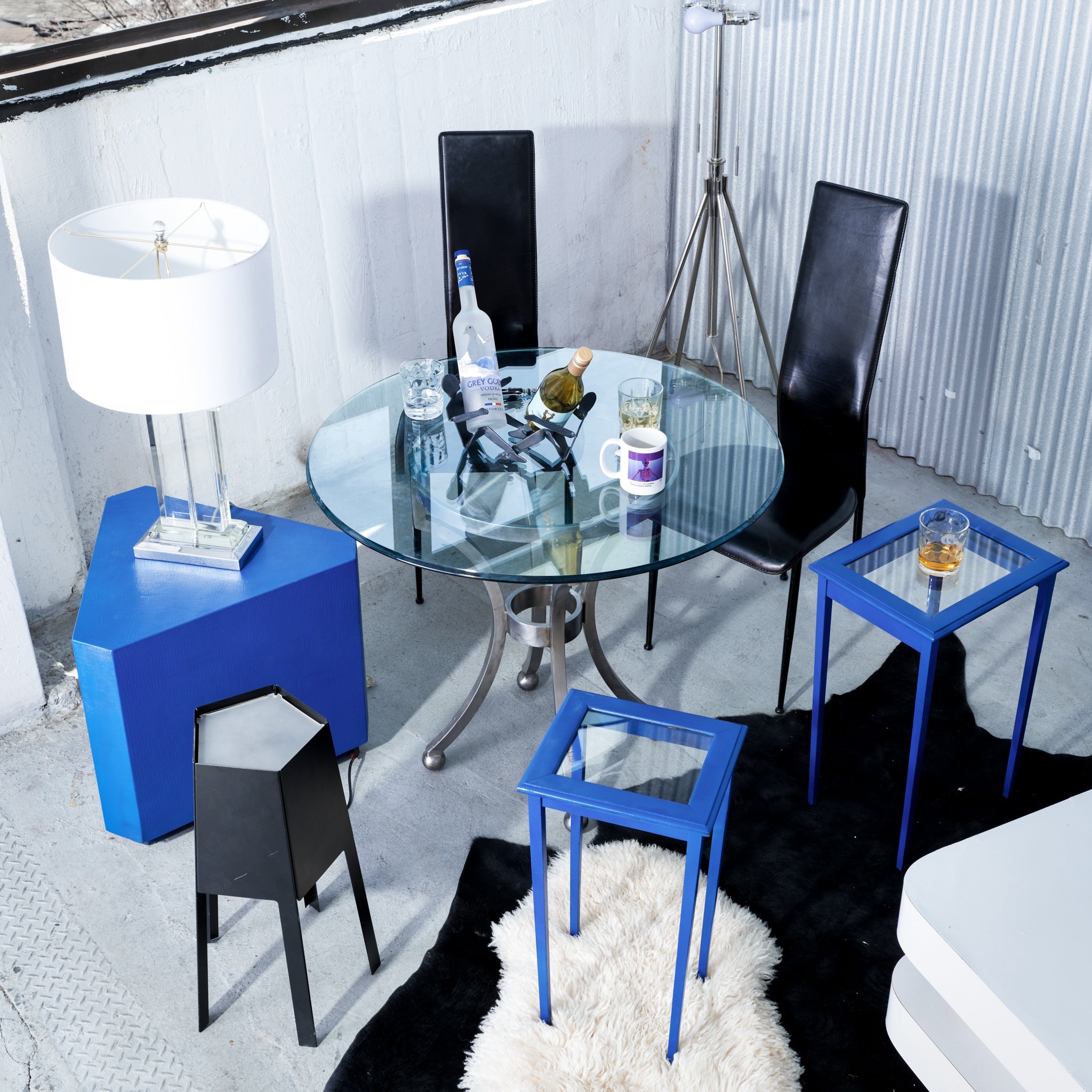 Modern interior with glass table and blue side tables in a stylish room.