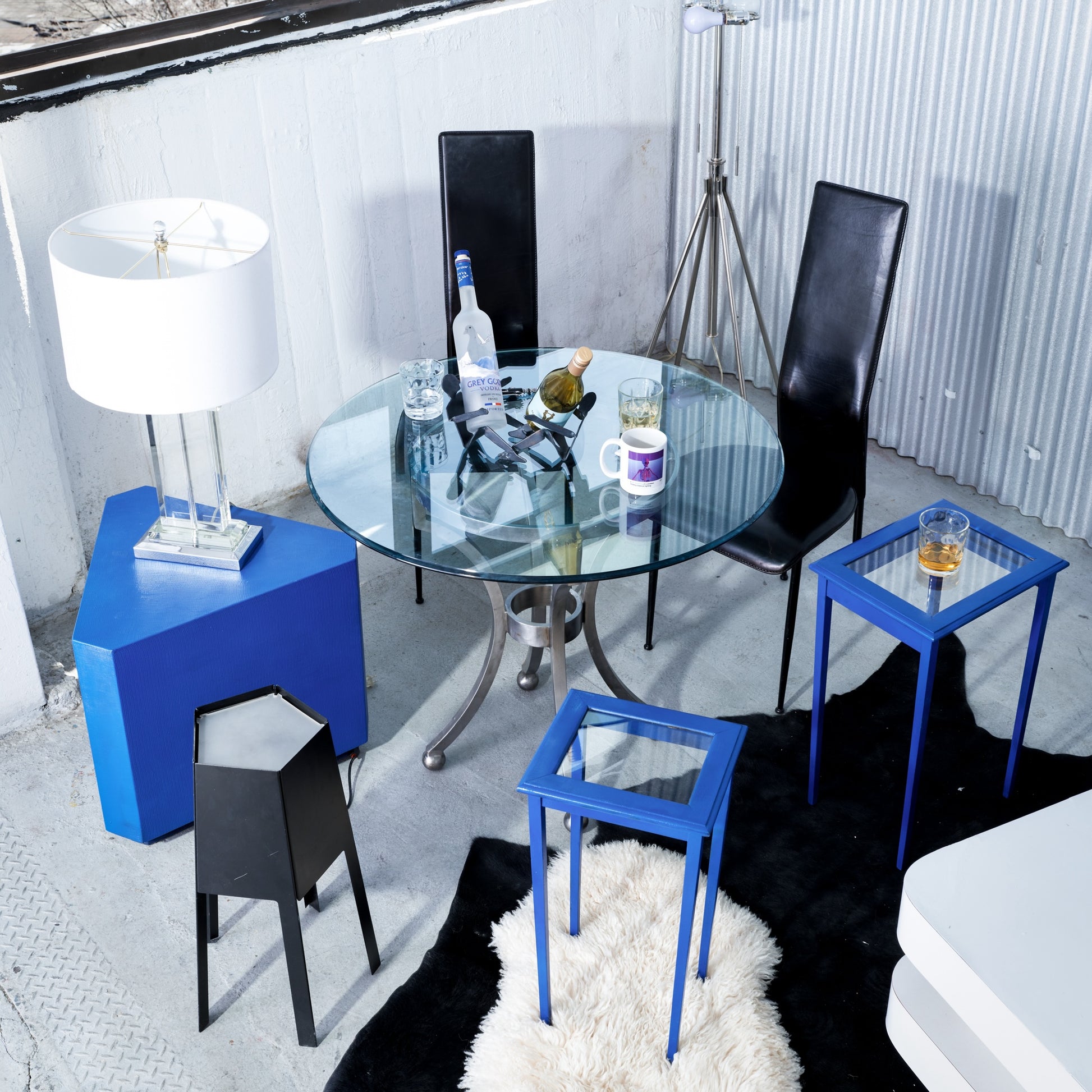 Modern interior with glass table and blue side tables in a stylish room.