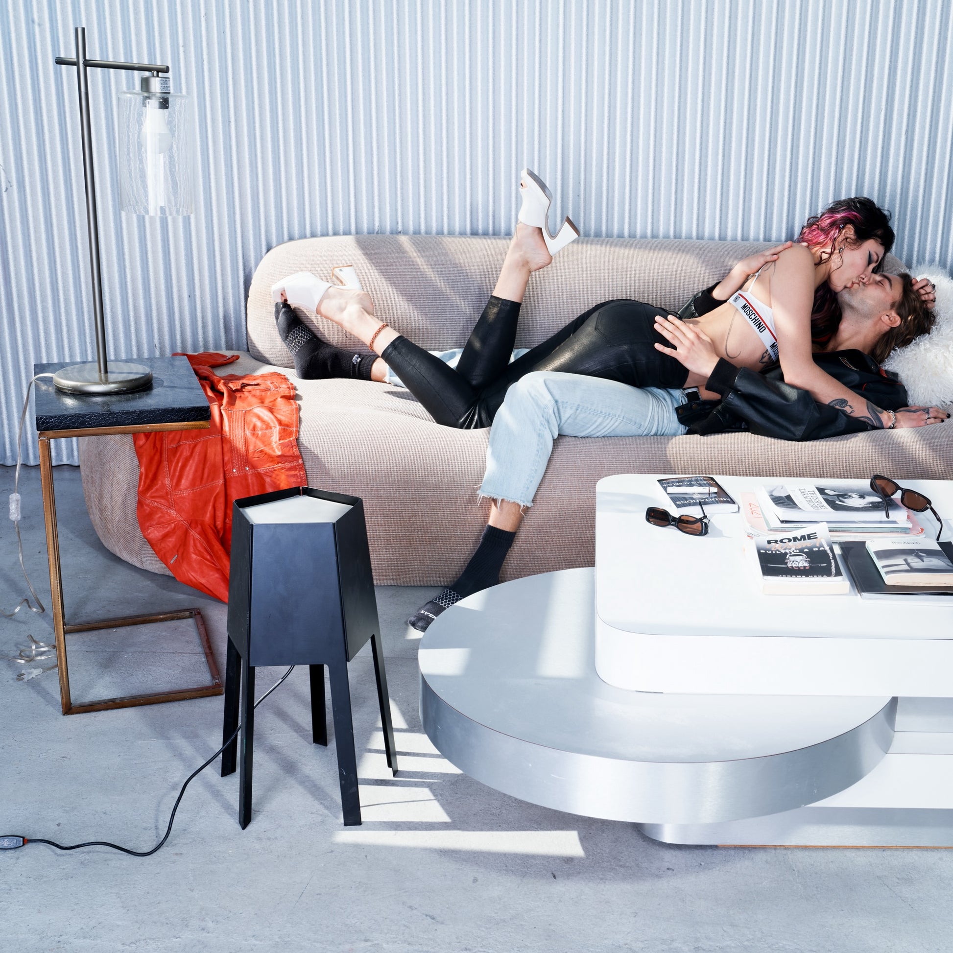 Two people embracing on a modern sofa in a stylish living room.