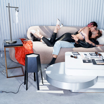 Two people embracing on a modern sofa in a stylish living room.