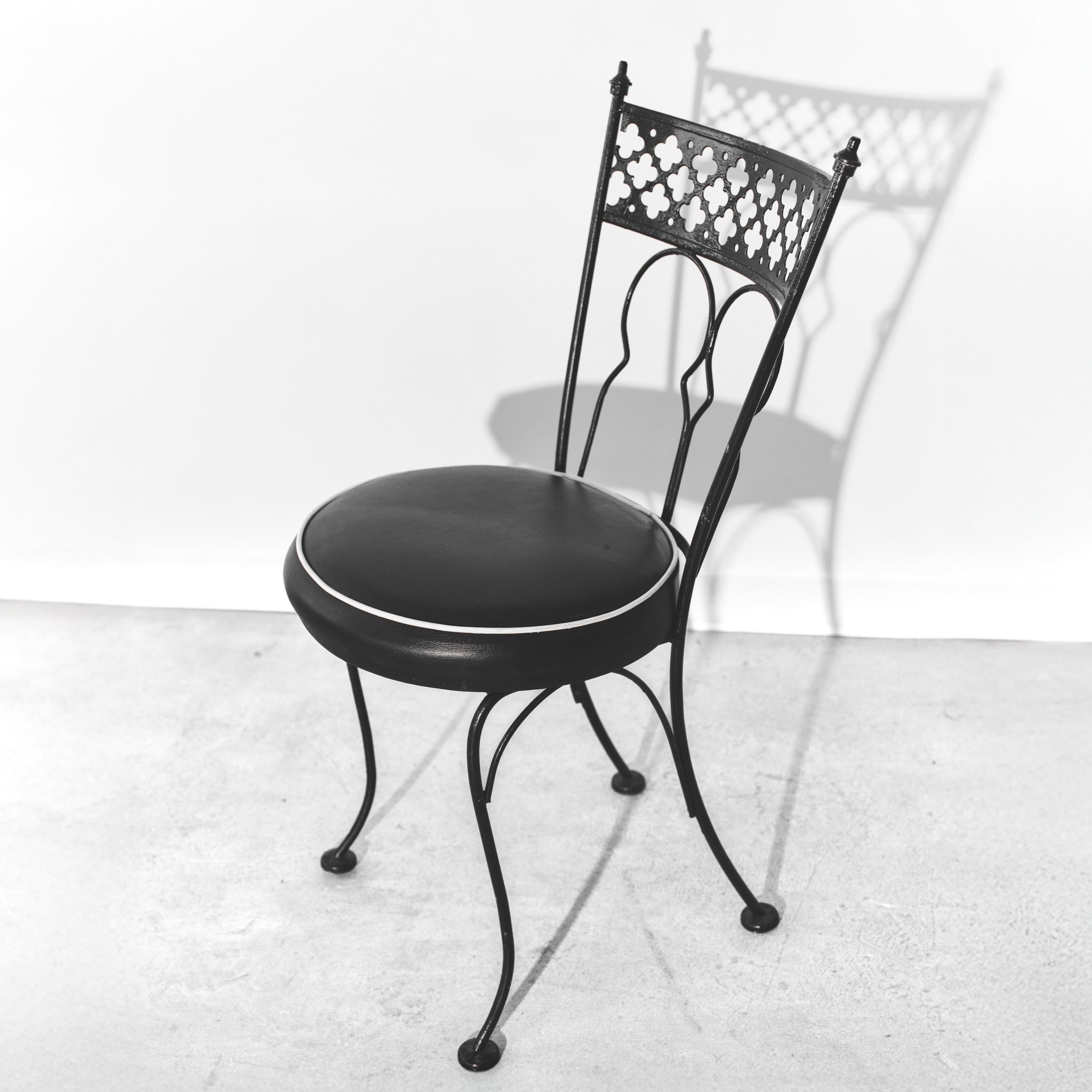 Black metal chair with cushioned seat on a white background