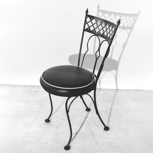 Black metal chair with cushioned seat on a white background