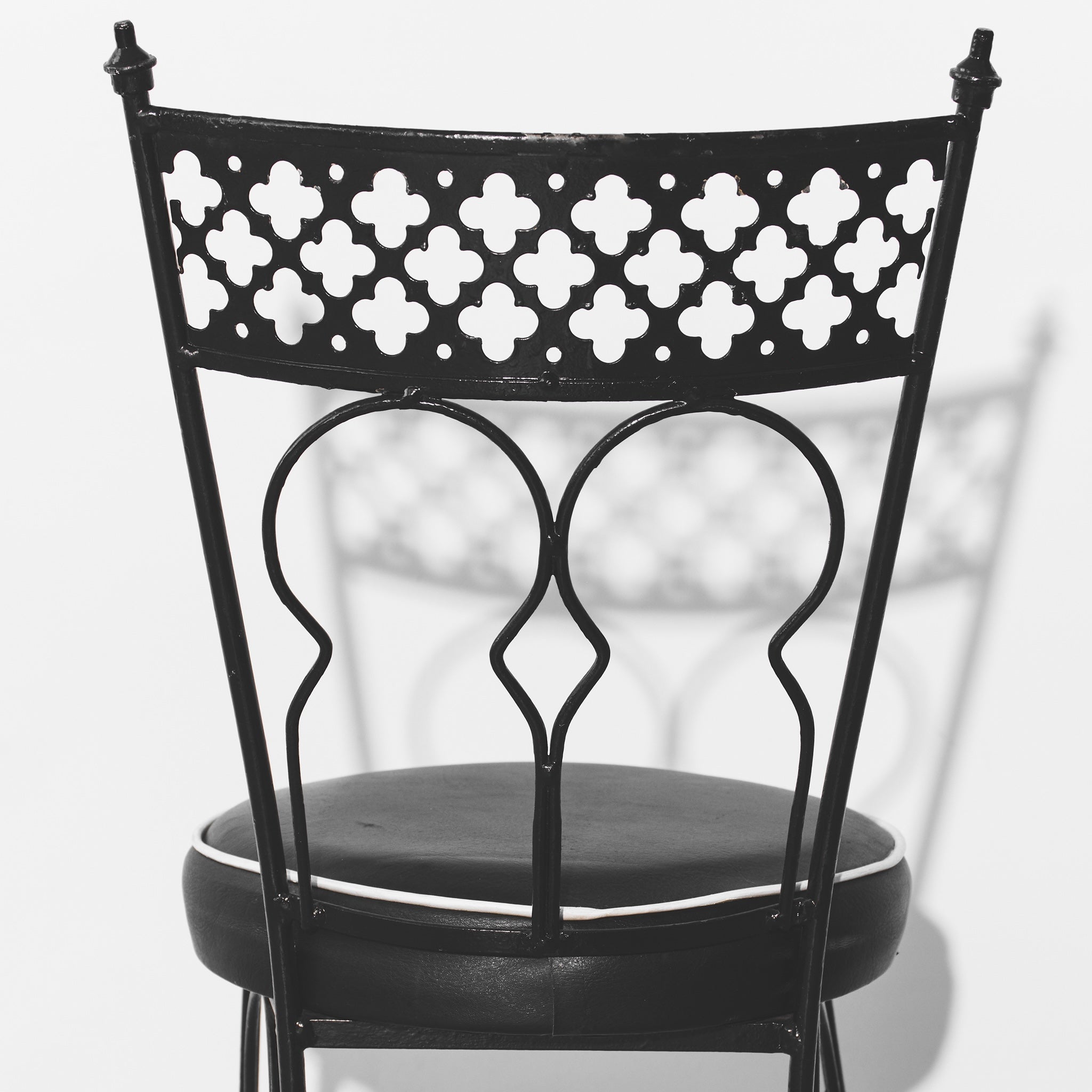 Black metal chair with decorative backrest on a white background
