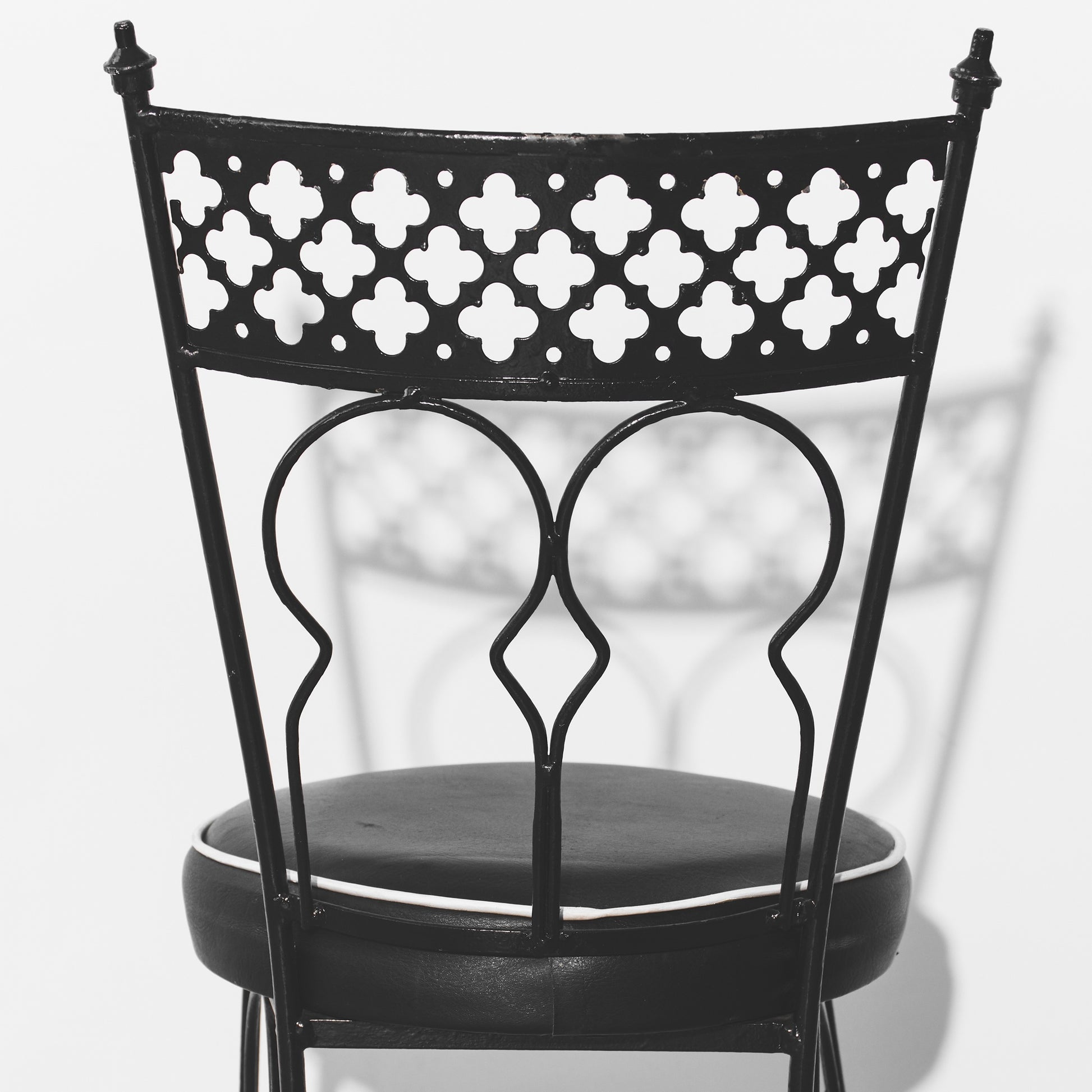 Black metal chair with decorative backrest on a white background