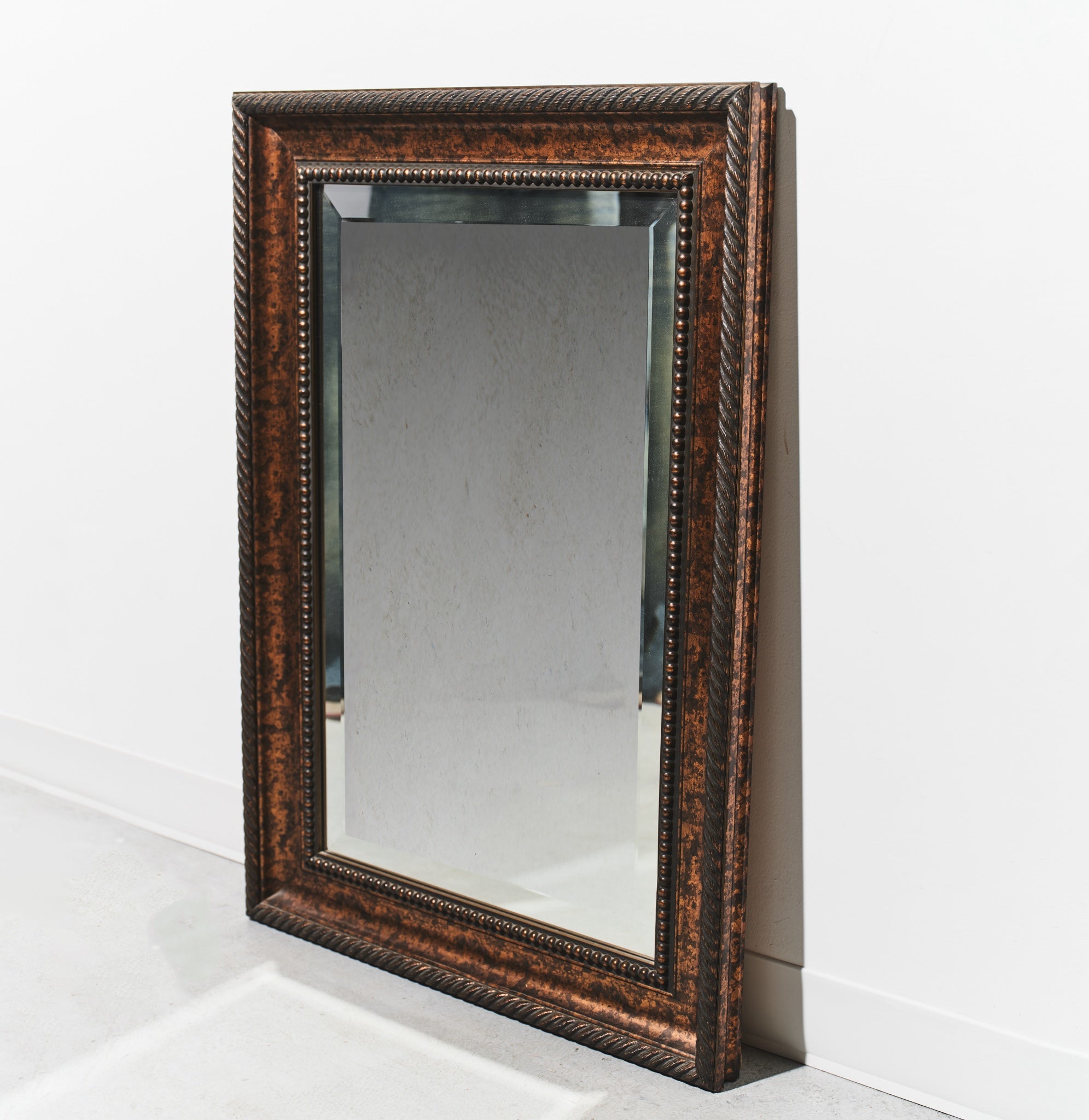 Rectangular mirror with decorative brown frame on a white background