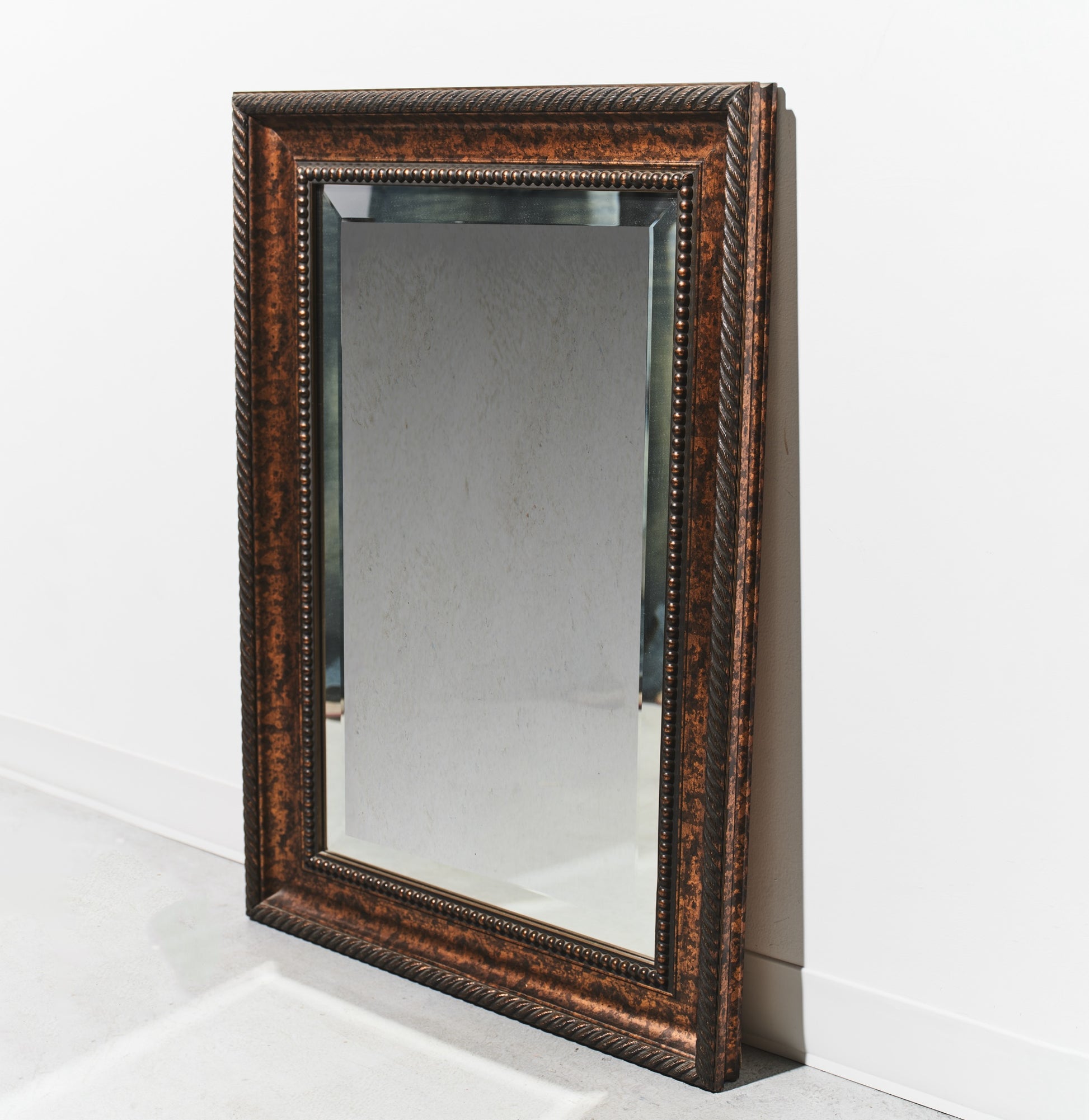 Rectangular mirror with decorative brown frame on a white background