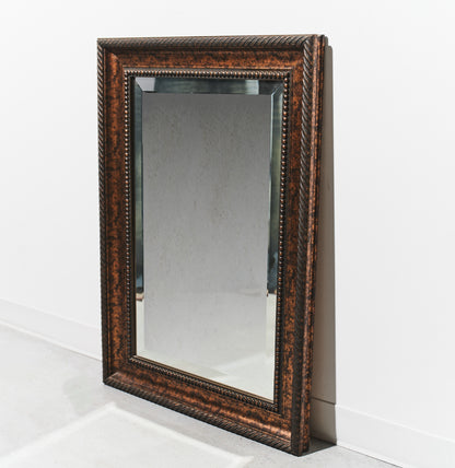 Rectangular mirror with decorative brown frame on a white background