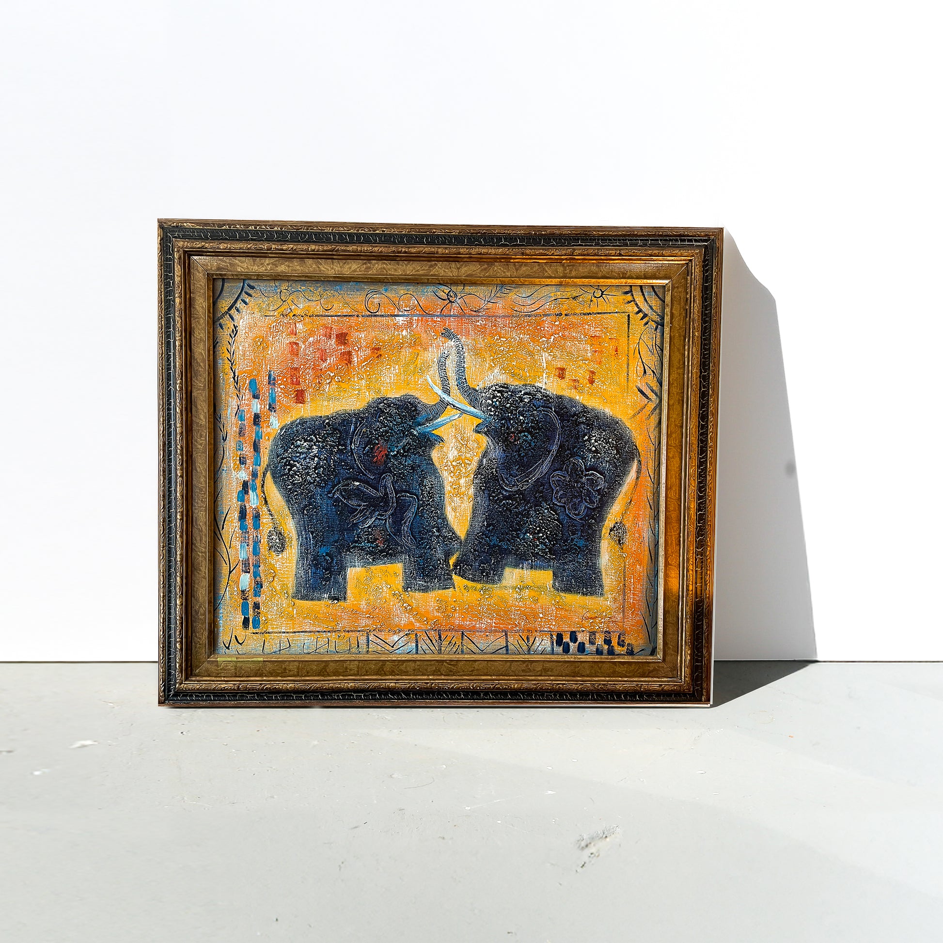 Framed artwork of two elephants on a white surface