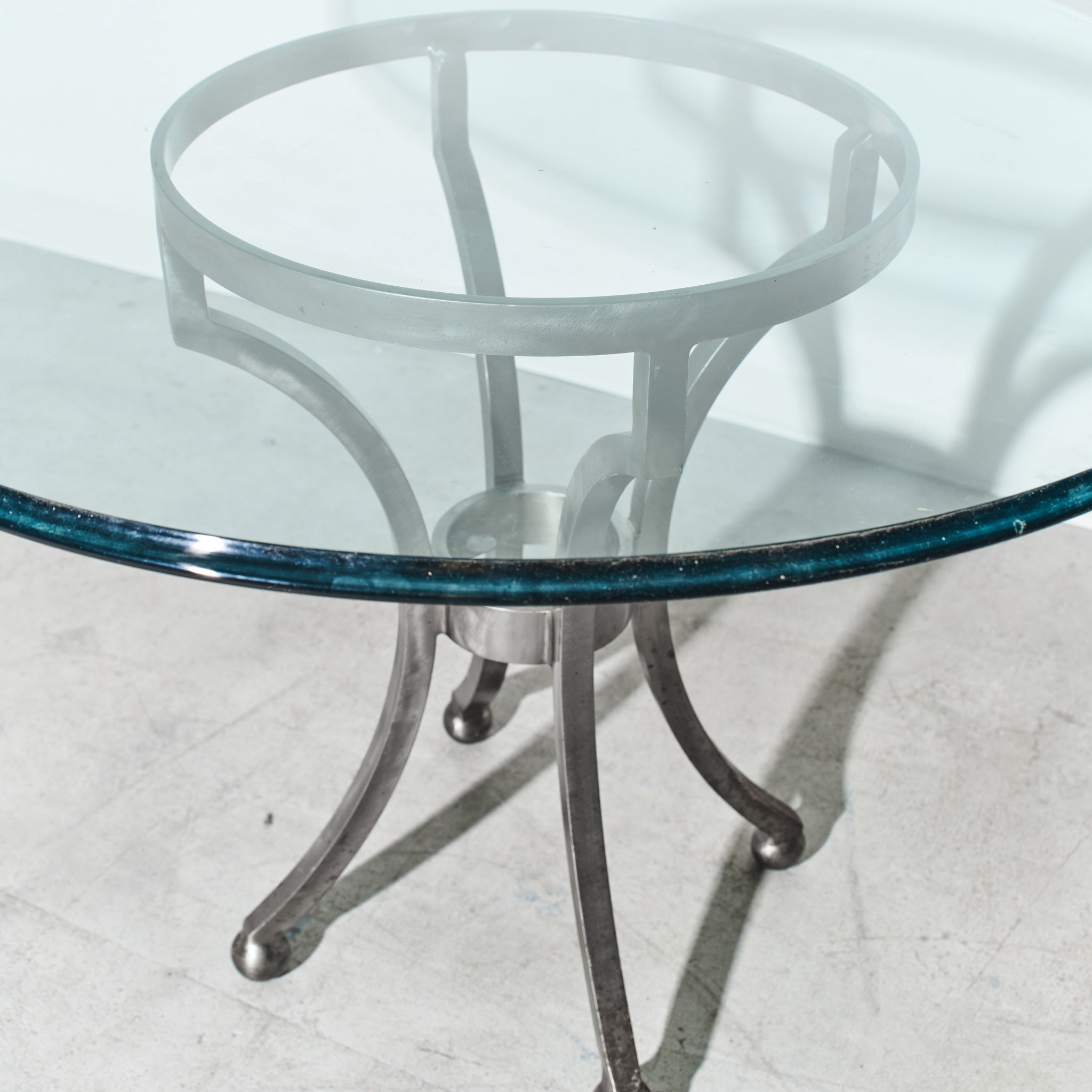 Glass table with metal base on a white floor