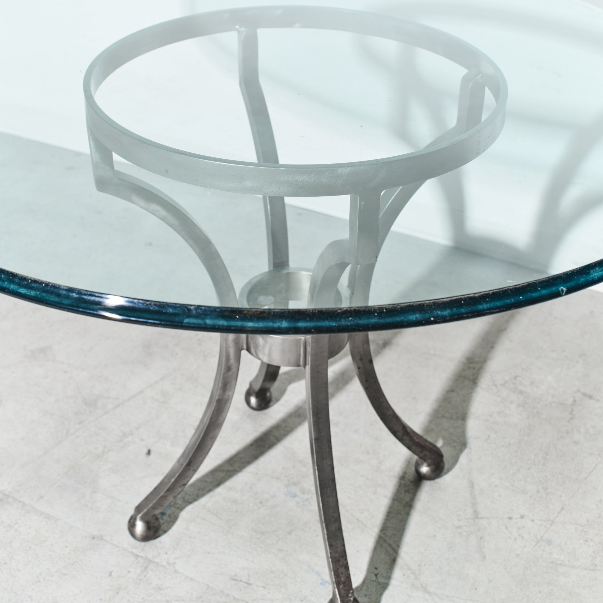 Glass table with metal base on a white floor