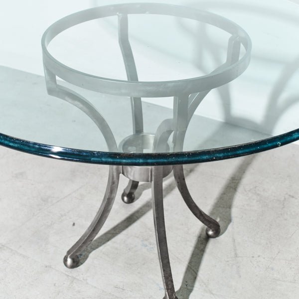 Glass table with metal base on a white floor
