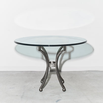 Round glass table with metal base on a white background