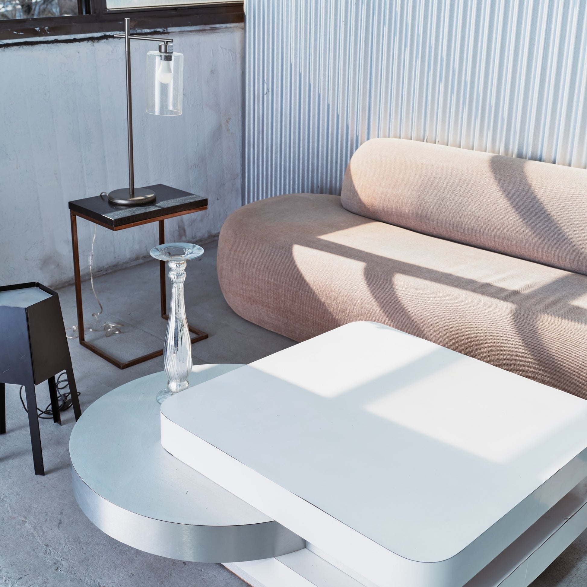 Modern living room with a white coffee table, beige sofa, and side table.