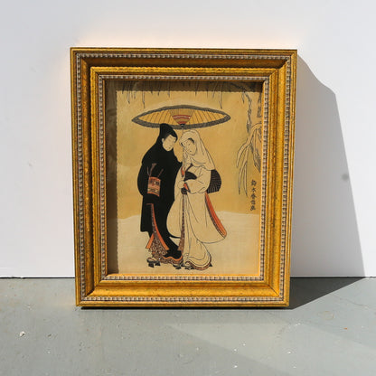 Framed artwork of two people under an umbrella on a plain background