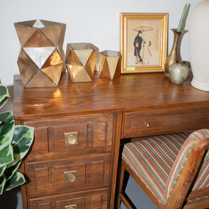 Wooden desk with decorative items including vases and a framed picture.