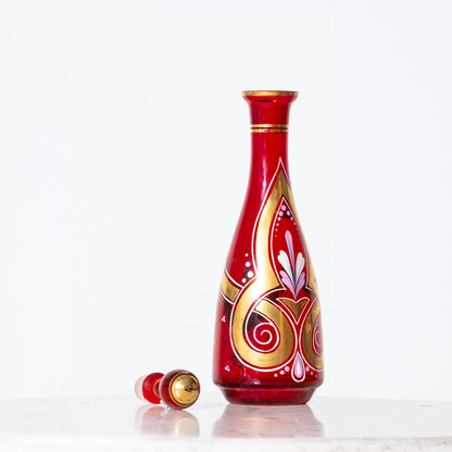Decorative red bottle with gold and white patterns on a white background
