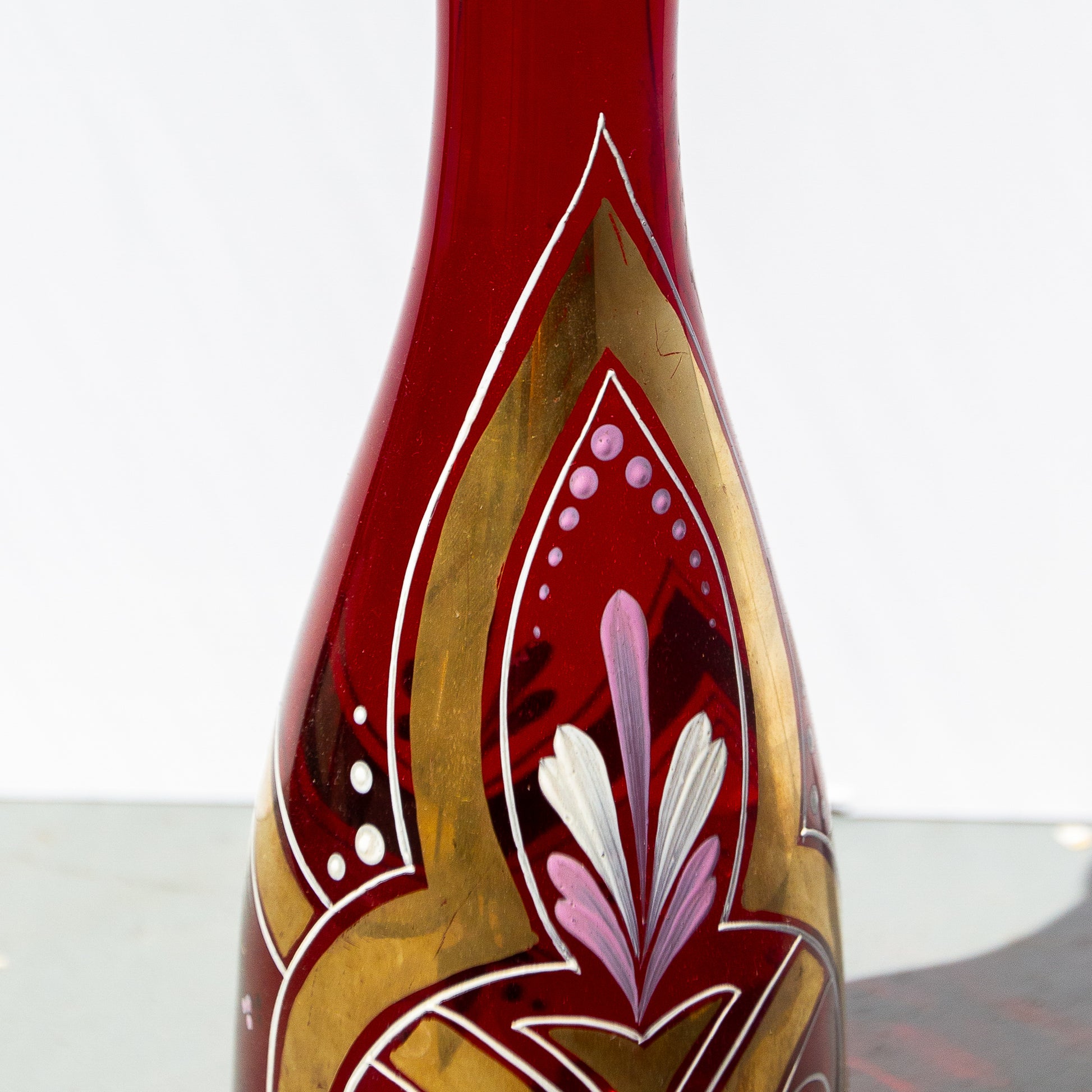 Decorative glass bottle with intricate designs on a white background