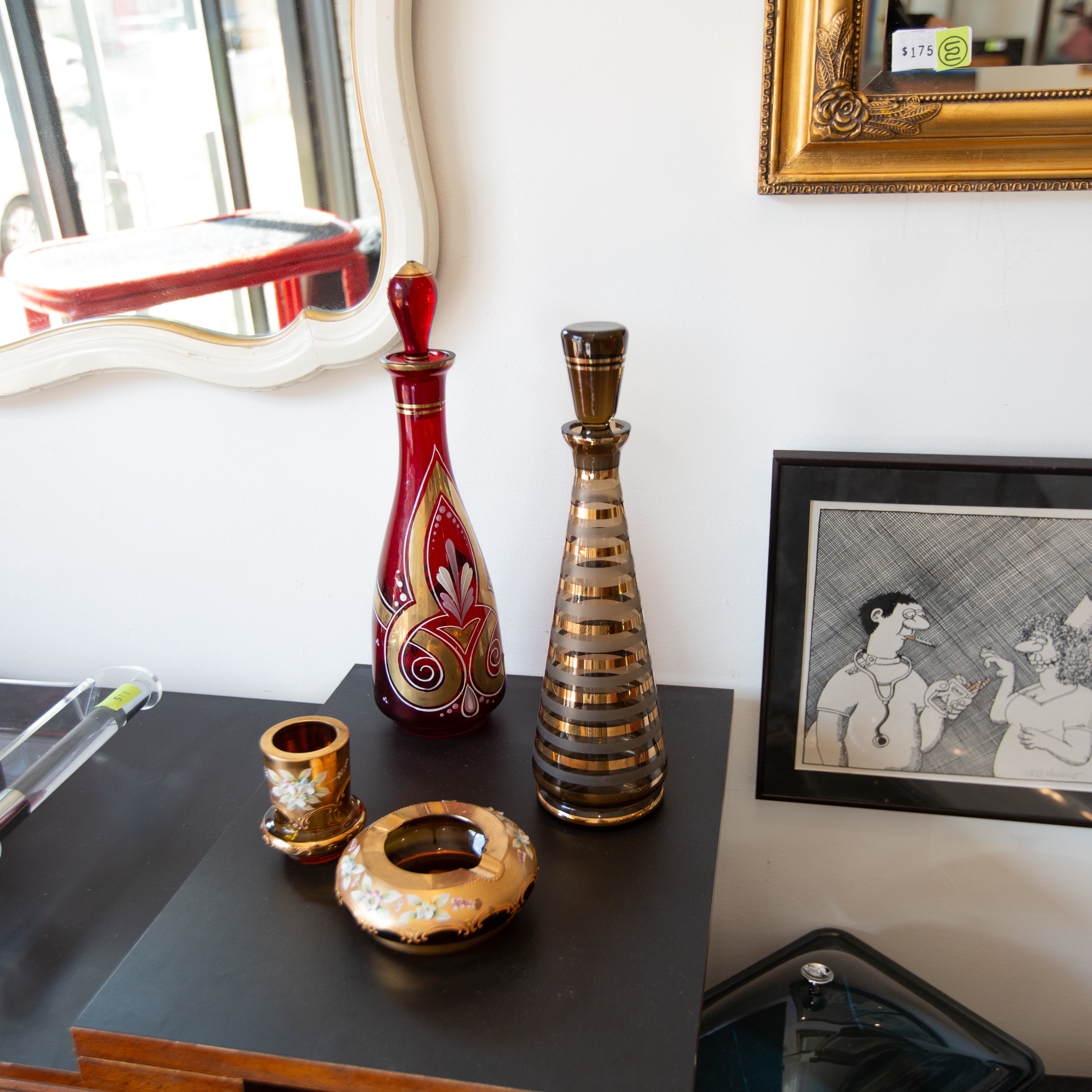 Decorative vases on a table with a framed picture in the background