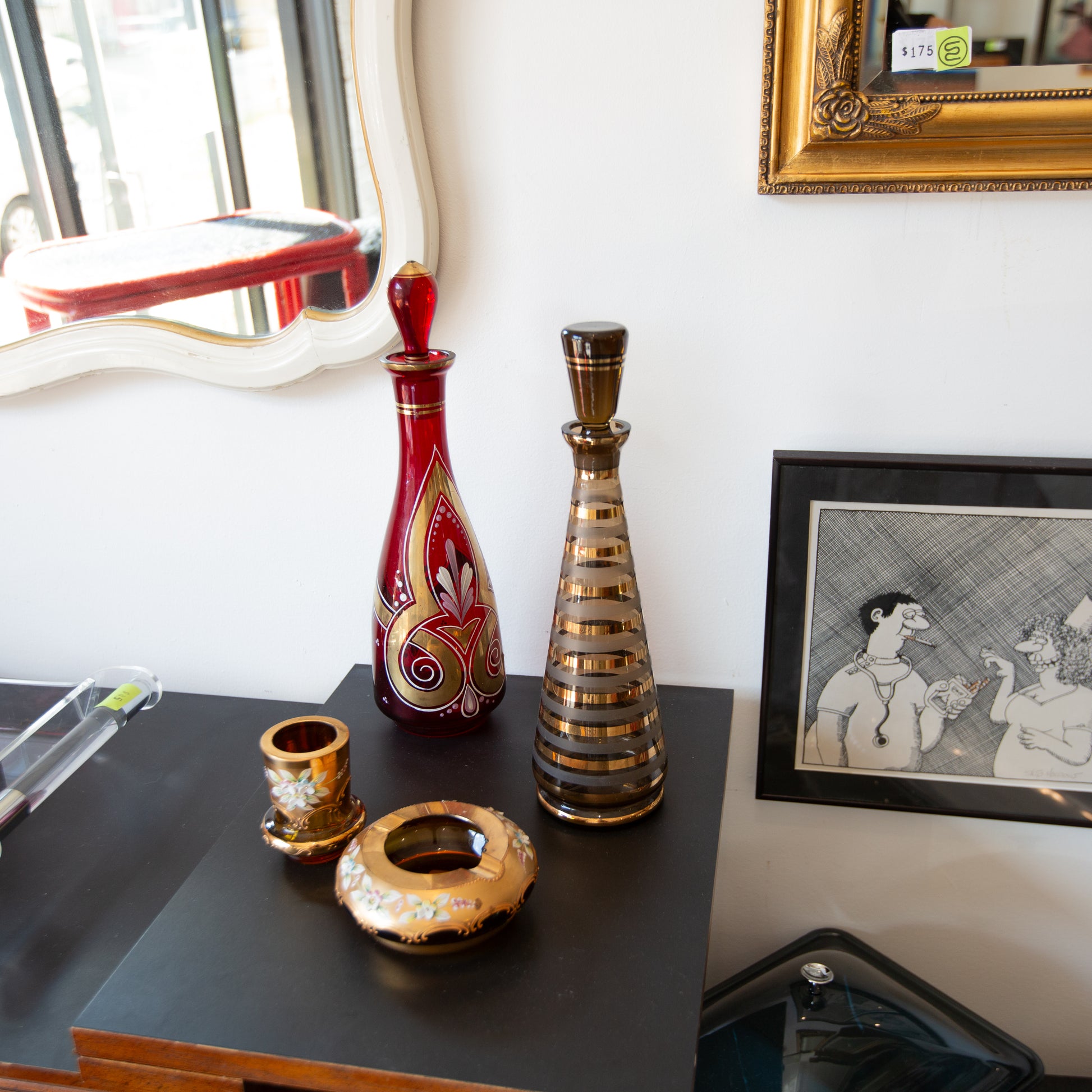Decorative vases on a table with a framed picture in the background