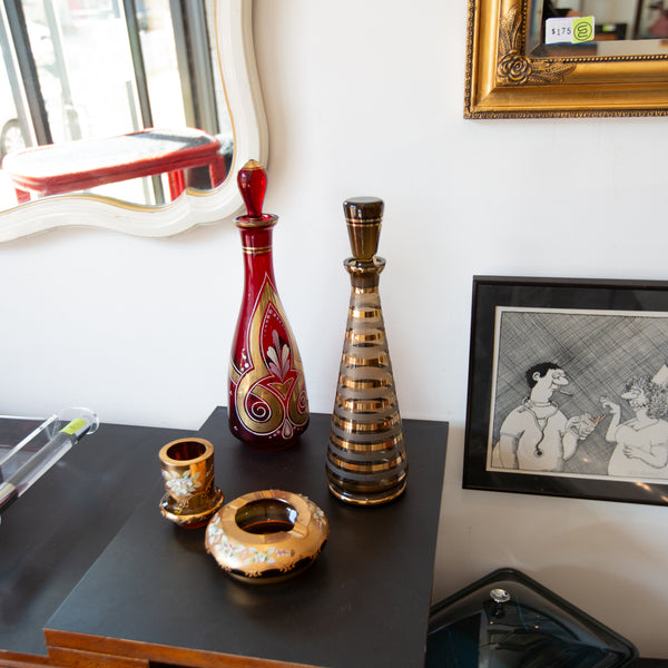 Decorative vases on a table with a framed picture in the background