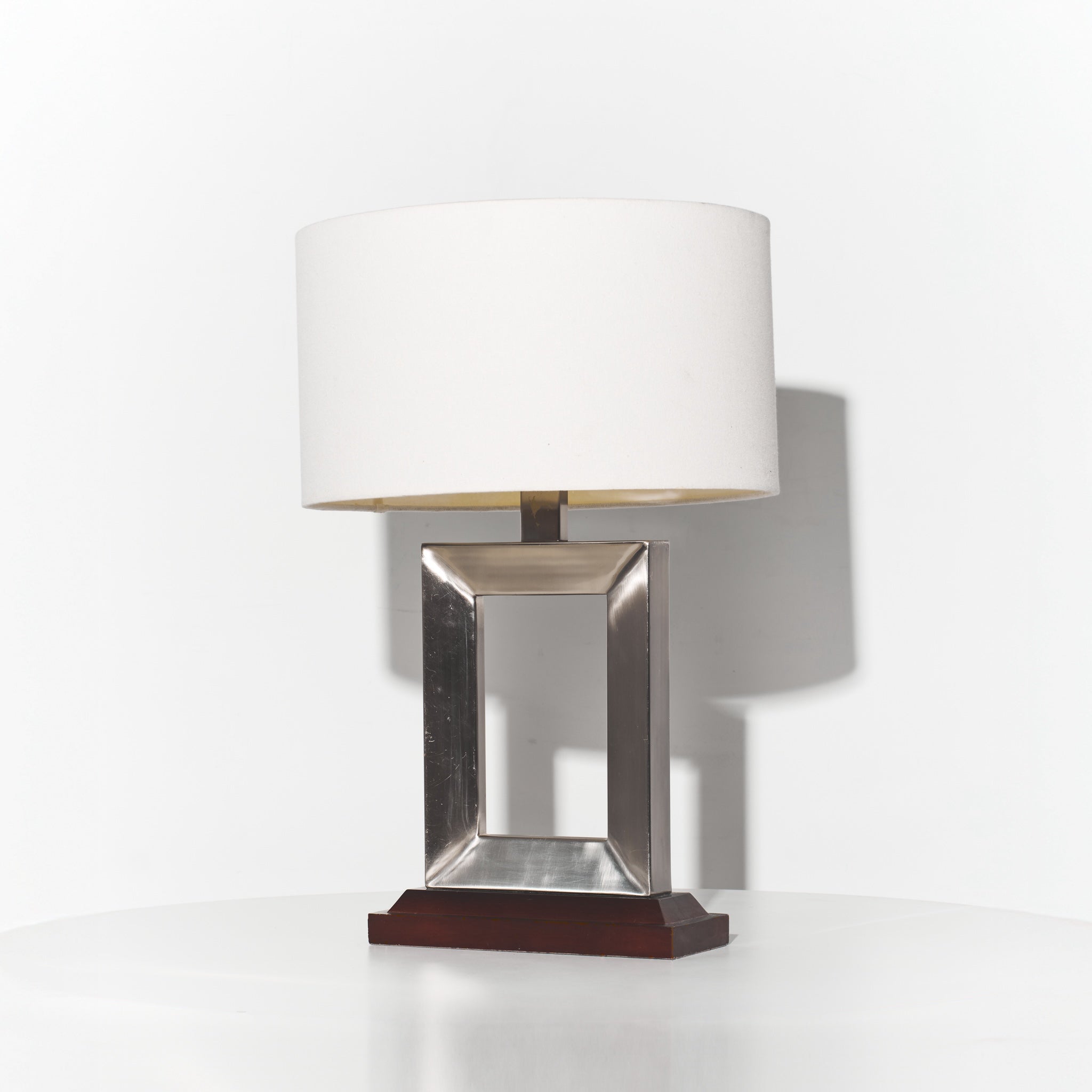 Table lamp with a metallic base and white shade on a white background