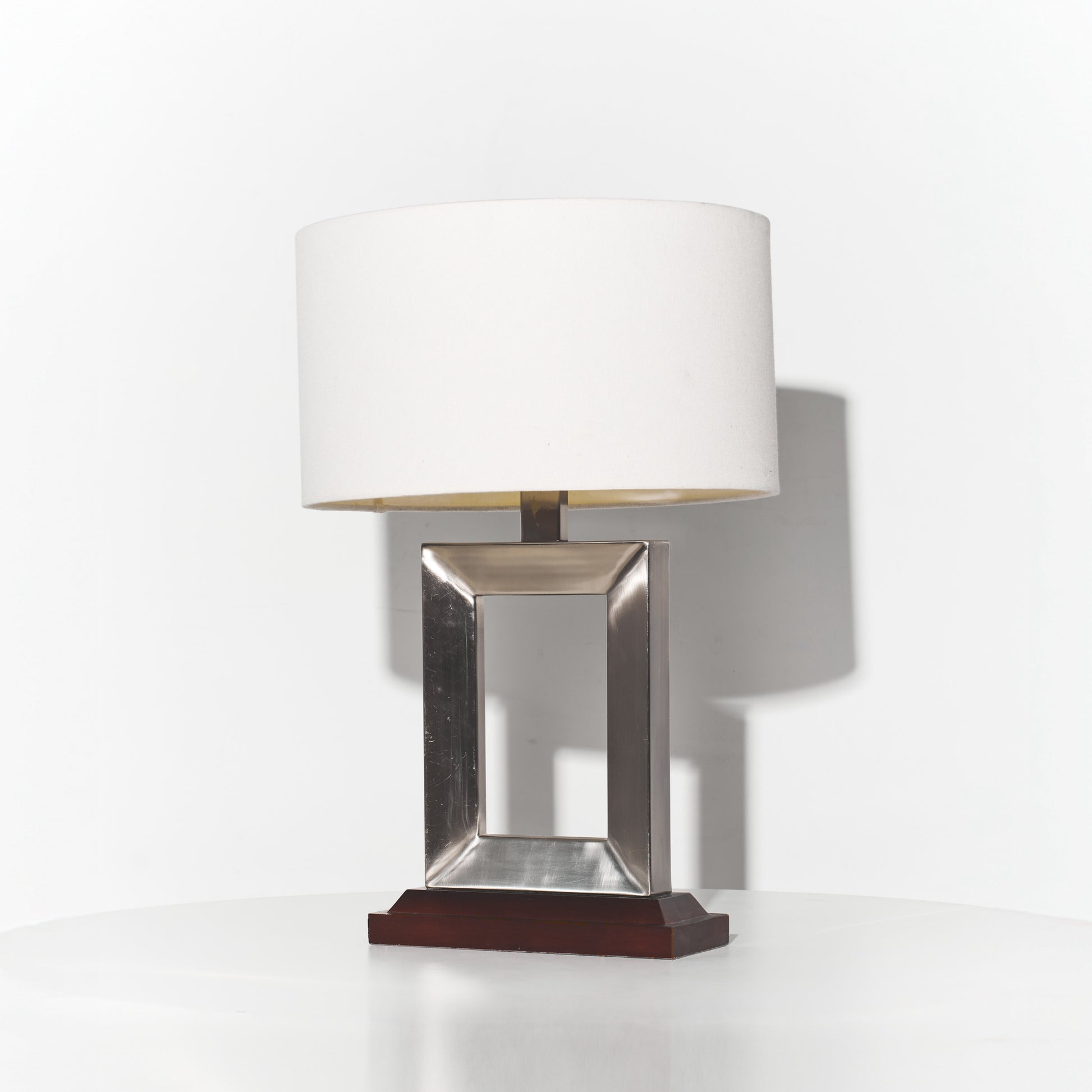 Table lamp with a metallic base and white shade on a white background