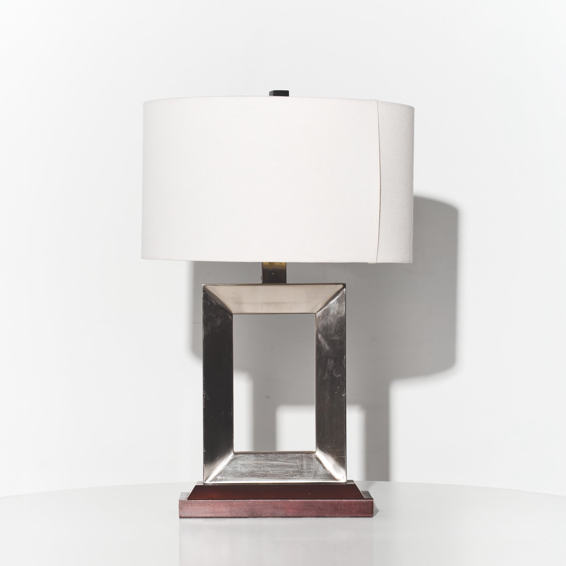 Table lamp with a white shade and metallic base on a white background