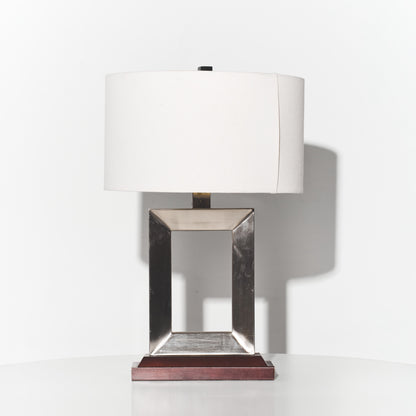 Table lamp with a white shade and metallic base on a white background
