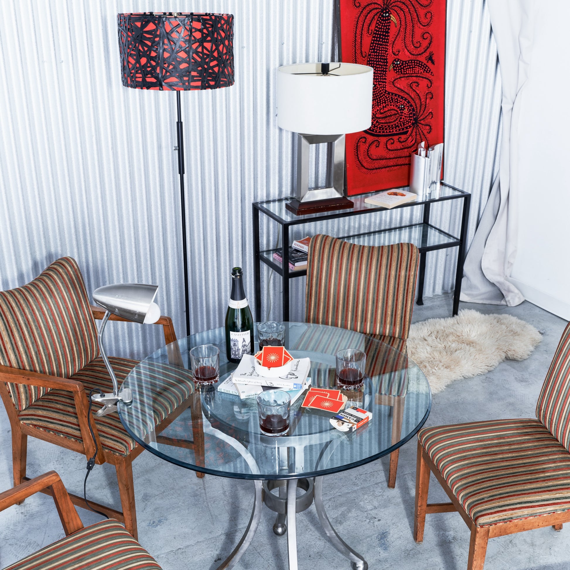 Dining room with a glass table, chairs, and decorative items.