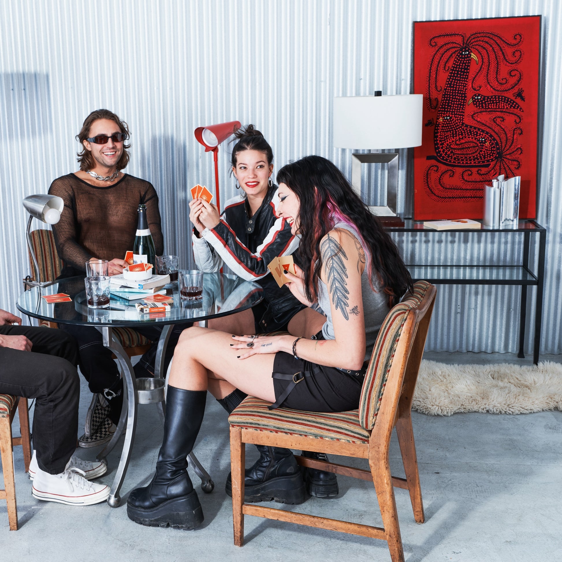 People sitting around a table in a modern room with a red abstract painting on the wall.