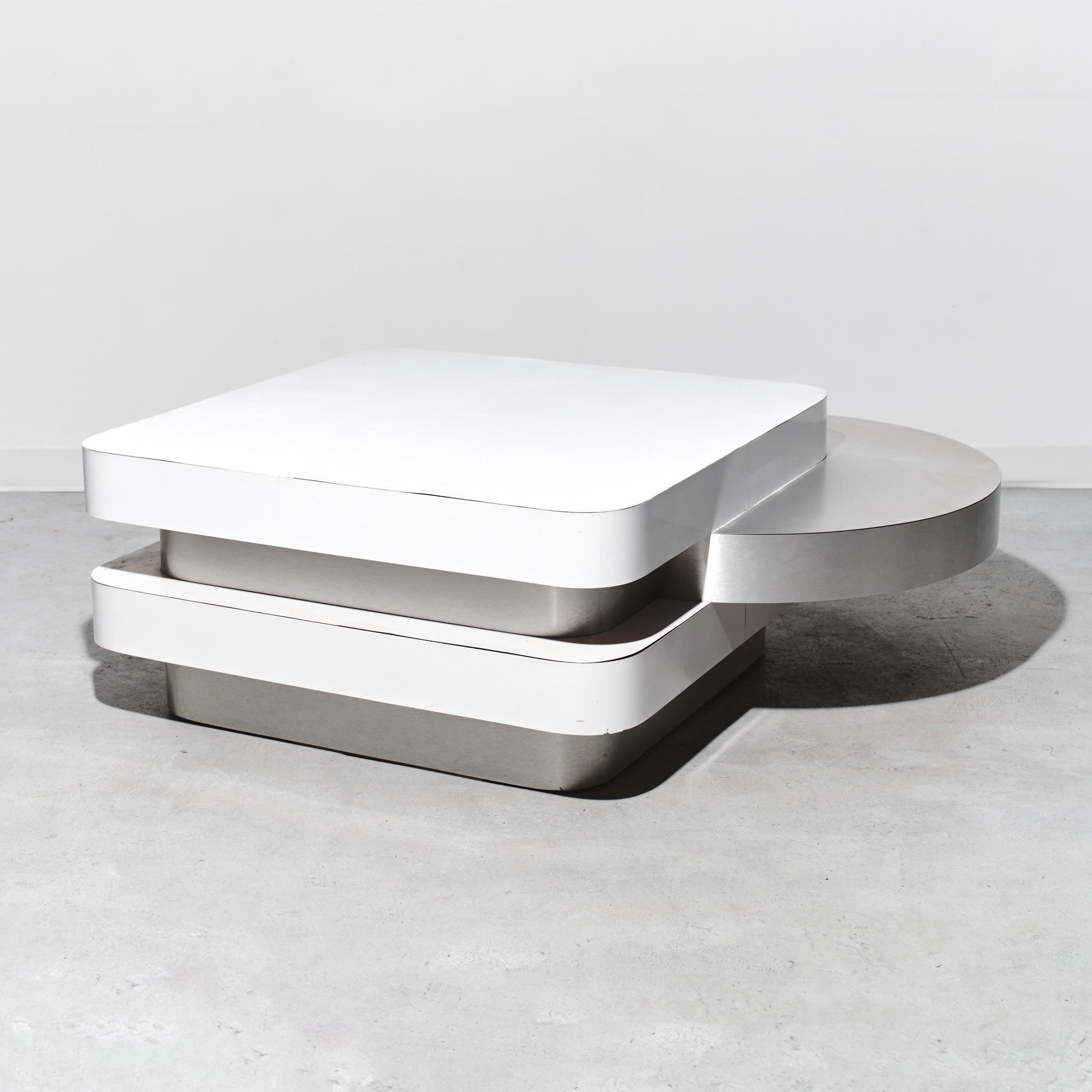 Modern white coffee table on a light gray surface with a neutral background
