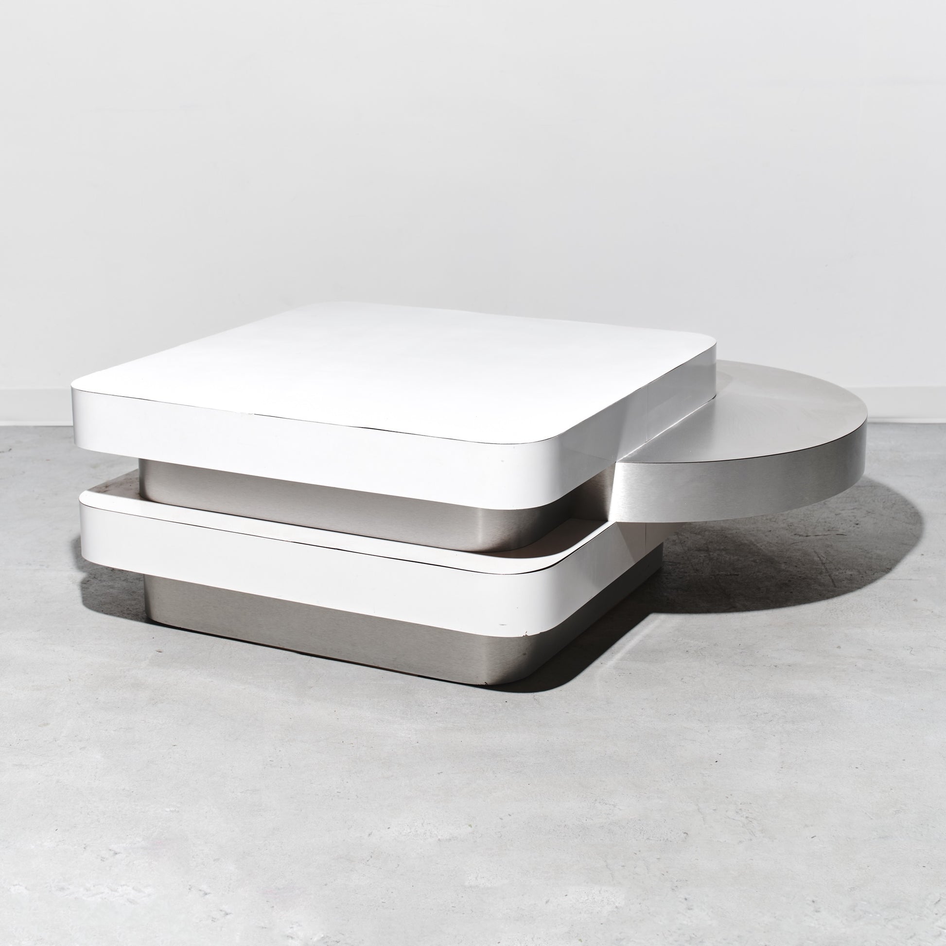 Modern white coffee table on a light gray surface with a neutral background
