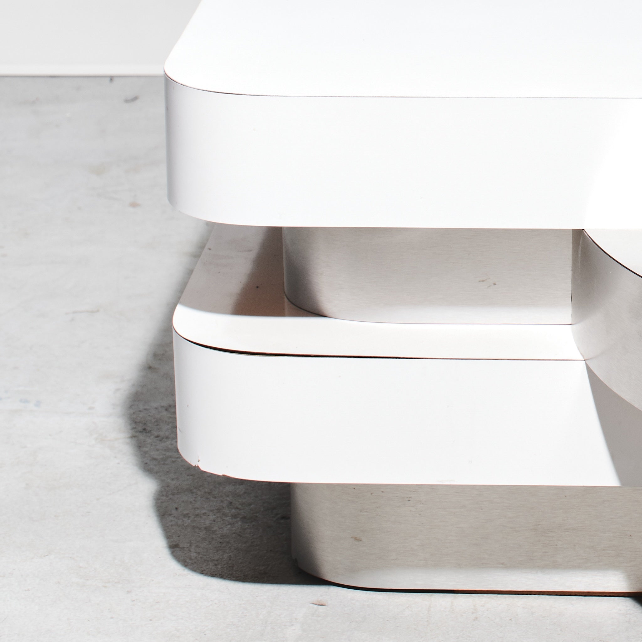 White trash can with a lid on a light gray floor