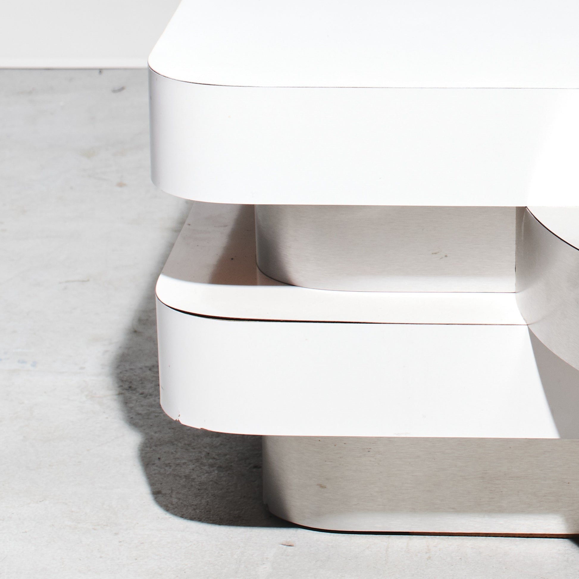 White trash can with a lid on a light gray floor