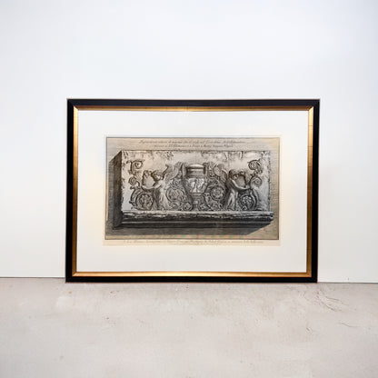 Framed artwork of a classical design on a white wall