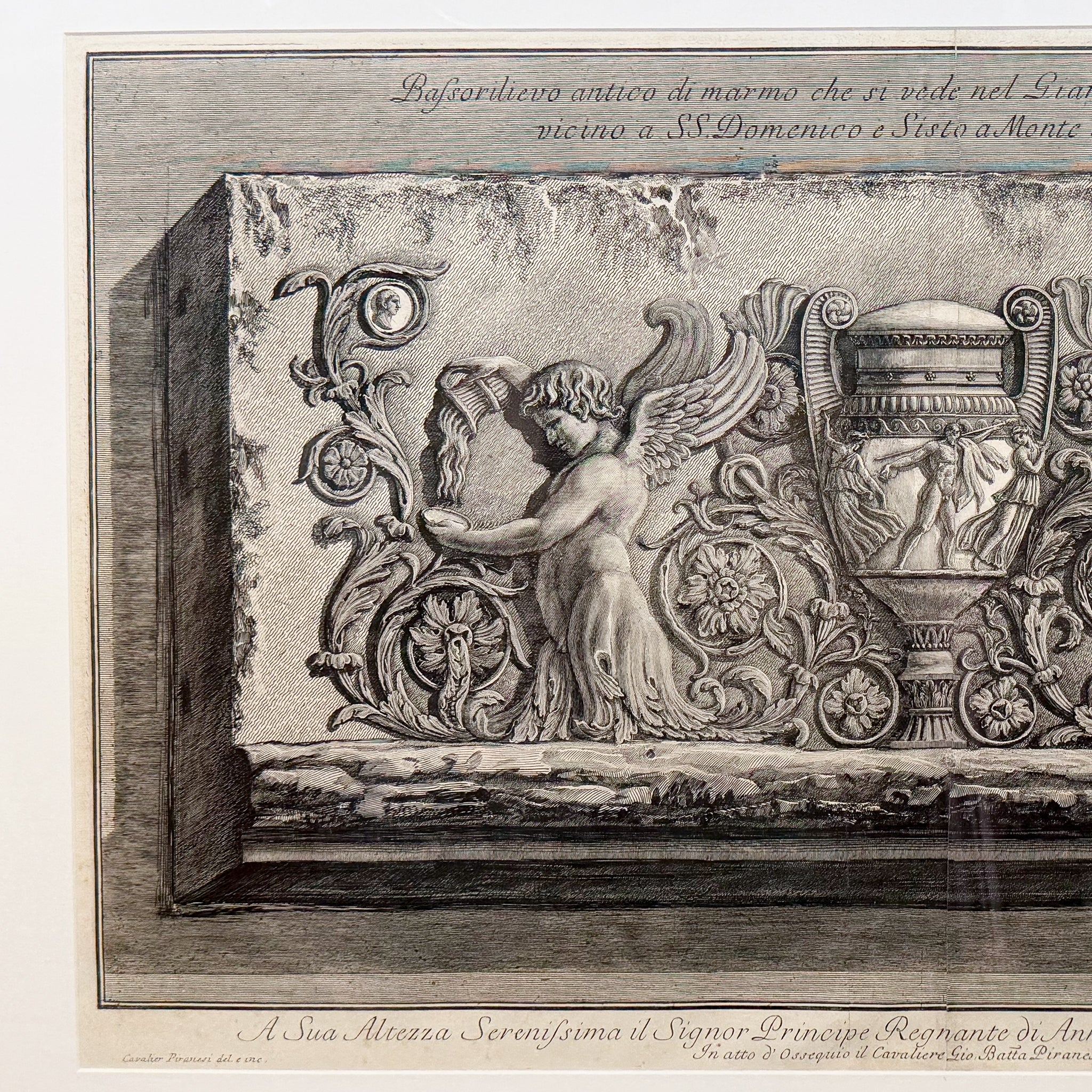 Decorative stone relief with angel and architectural elements, likely from a historical or classical building.