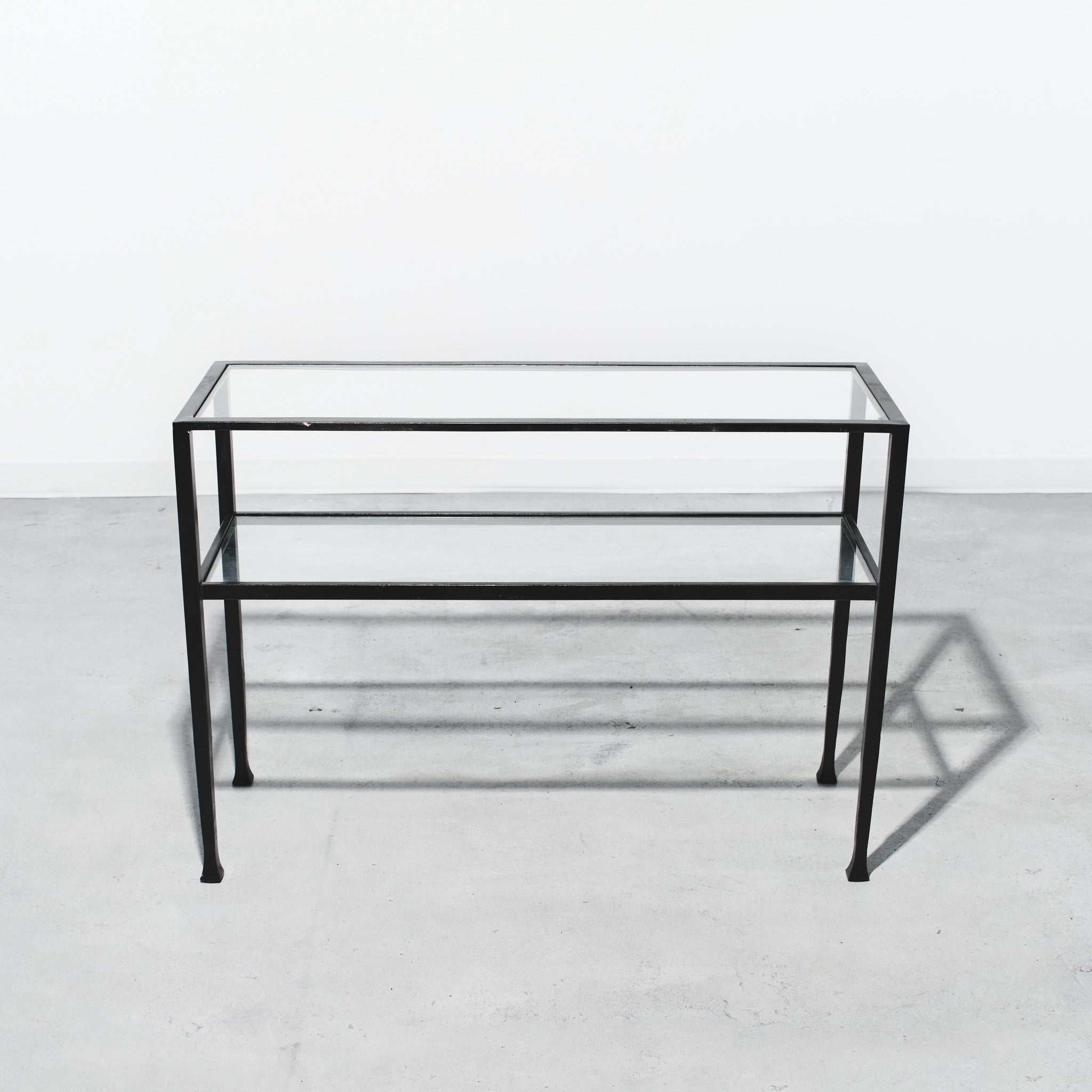 Glass table with black metal frame on a white background