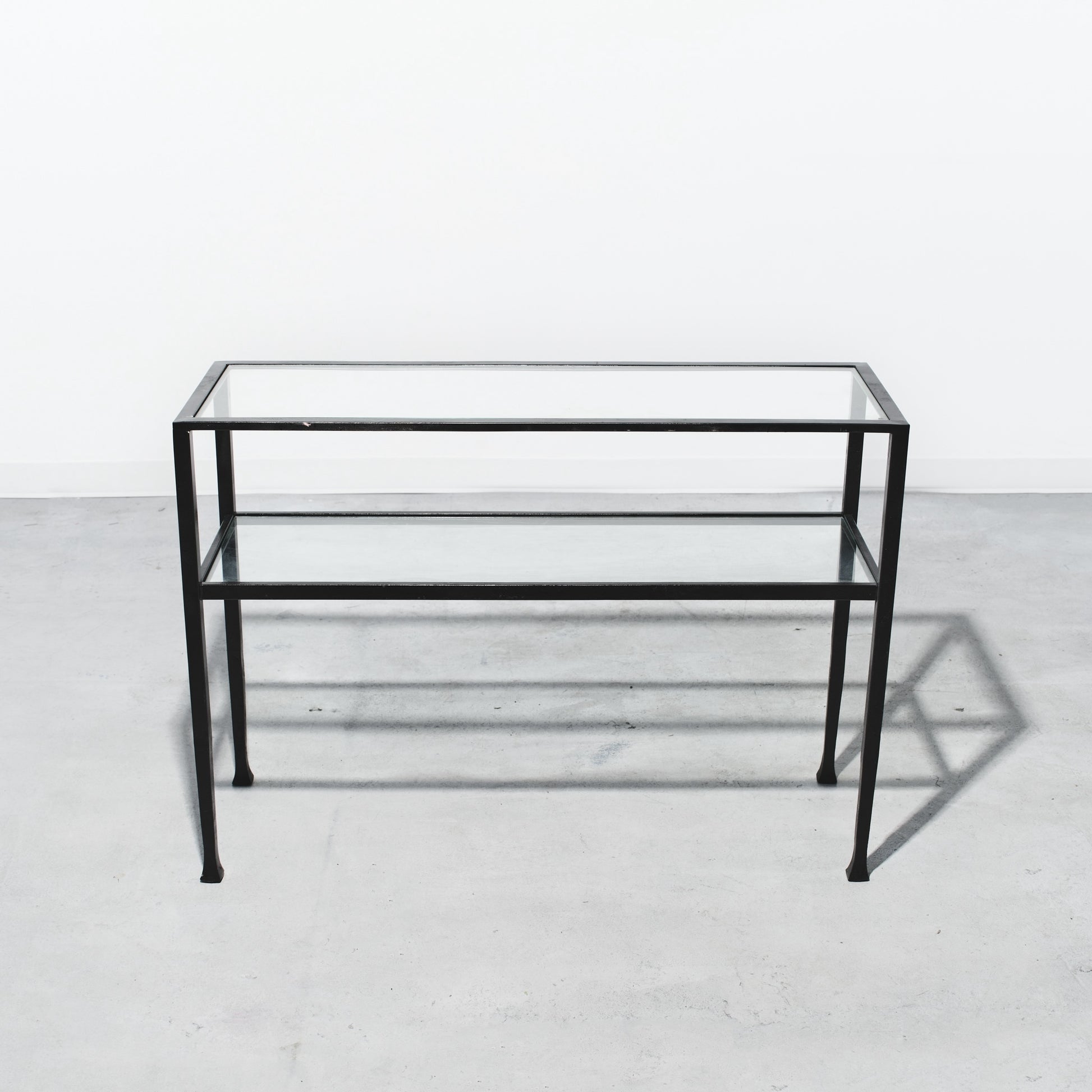 Glass table with black metal frame on a white background