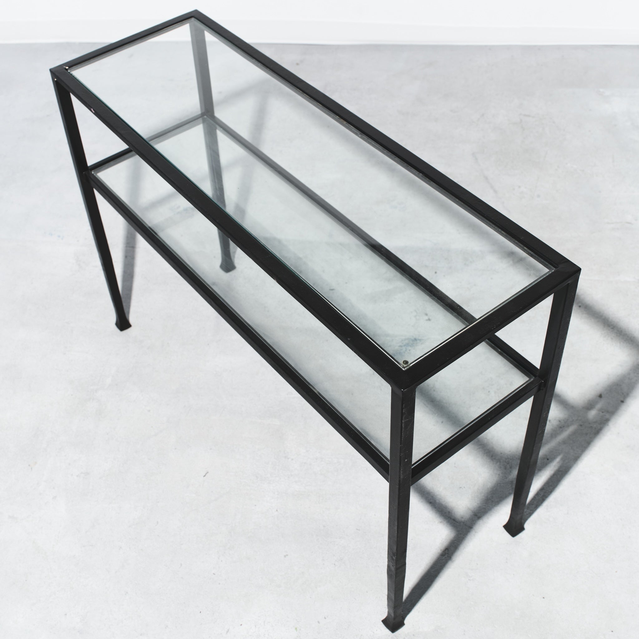 Glass display case with black metal frame on a white background
